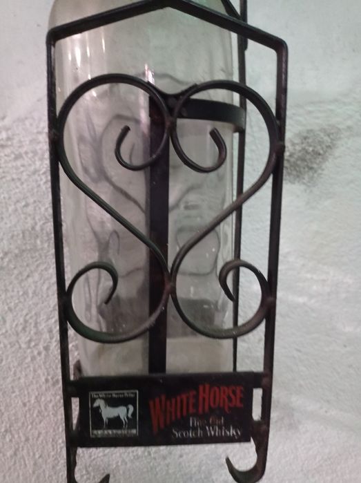 Suporte em ferro e garrafa de whisky.