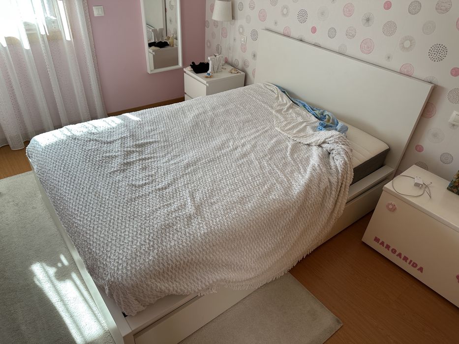 Cama de casal branca com colchão, com dimensões de 1,60 x 2 m. O