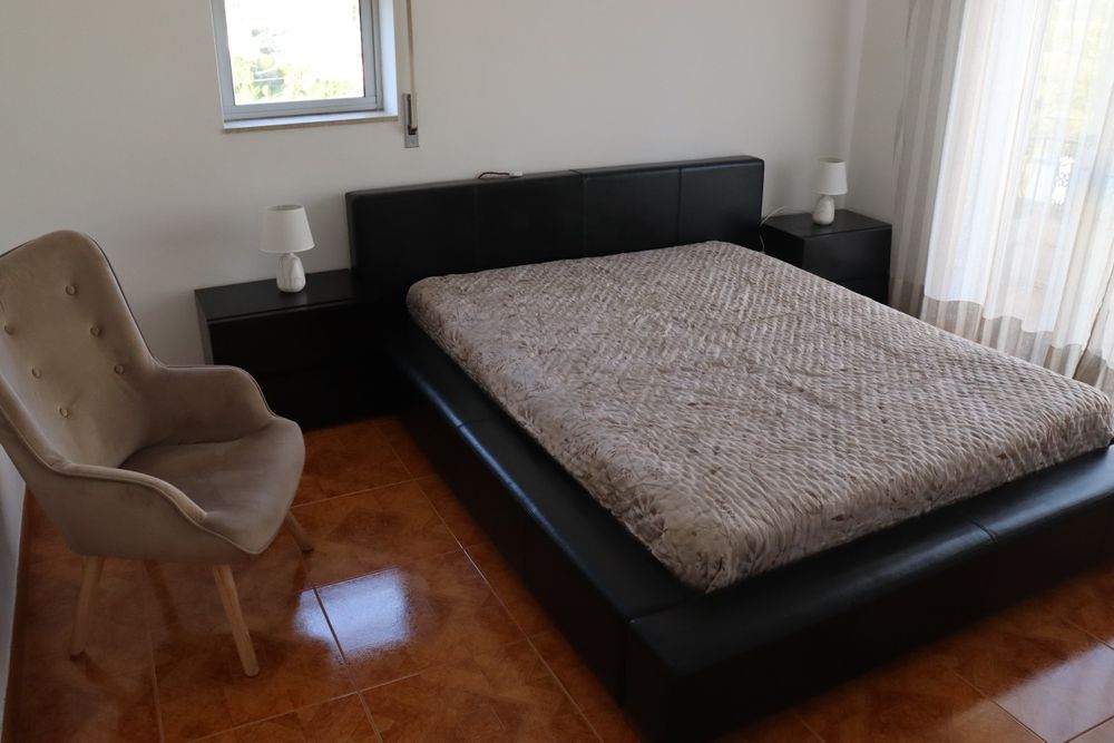 Cama casal preta e mesinhas