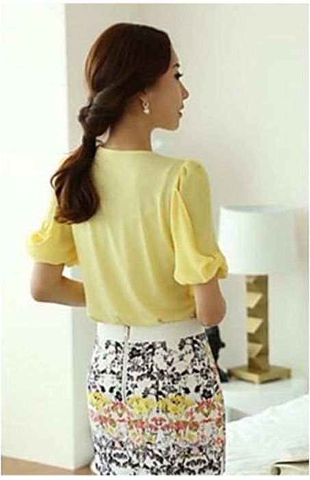 Blusa amarela com colar de perolas de fantasia