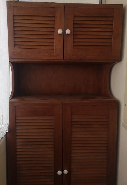 Armário com cama arrumada e colchão.