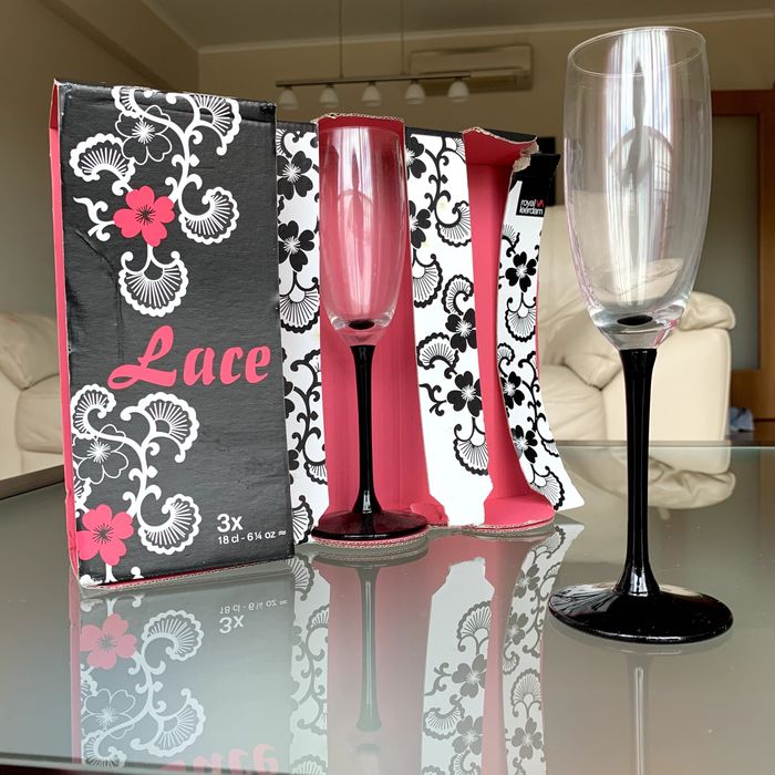 Conjunto de três flutes de champagne em vidro transparente e preto.