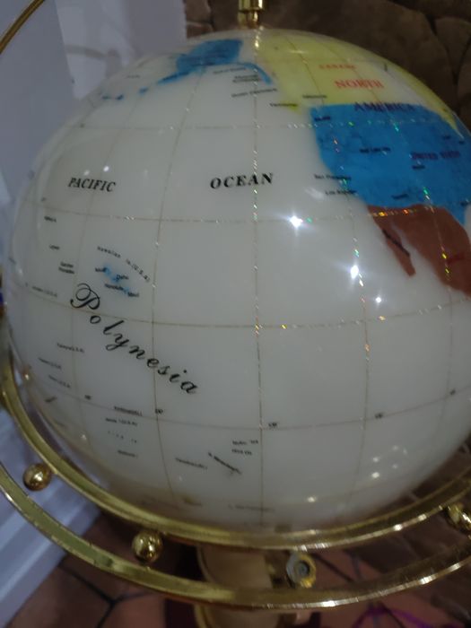 Globo com o mapa do mundo com estrutura em pedra e com base de madeira