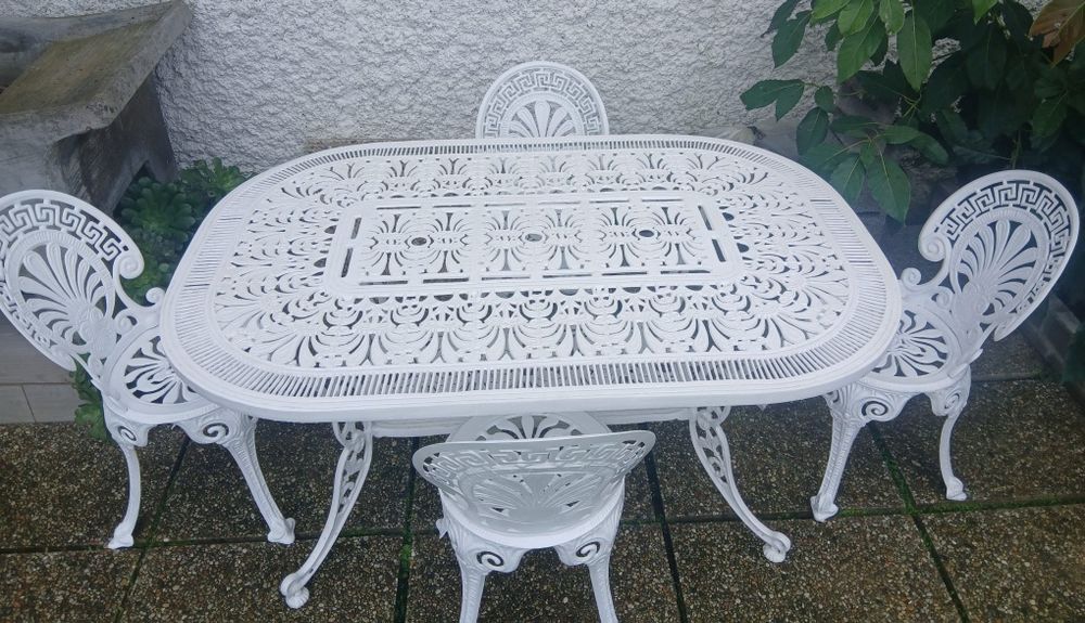 Uma mesa e 4 cadeiras de jardim