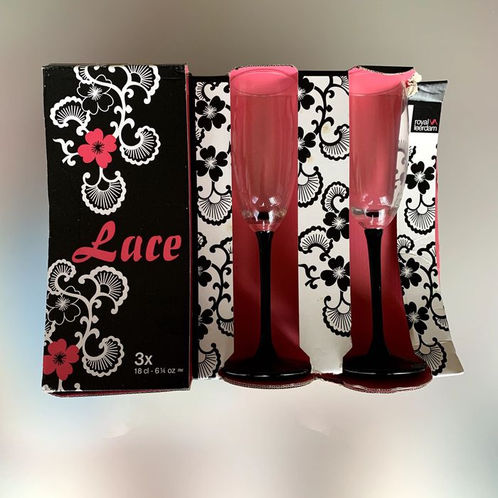 Conjunto de três flutes de champagne em vidro transparente e preto.