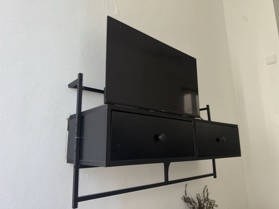 Estante preta pendurada para tv