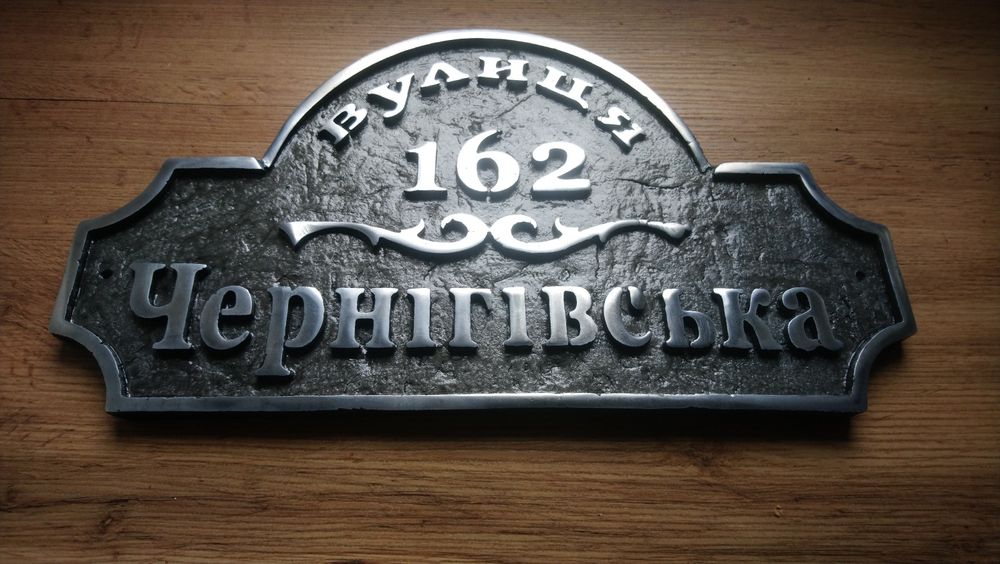 Табличка з адресою на будинок. Адресна табличка вилита з металу.
