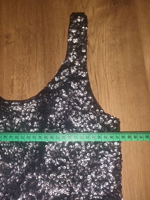 Cekinowa sukienka na ramiączkach i odkrytymi plecami