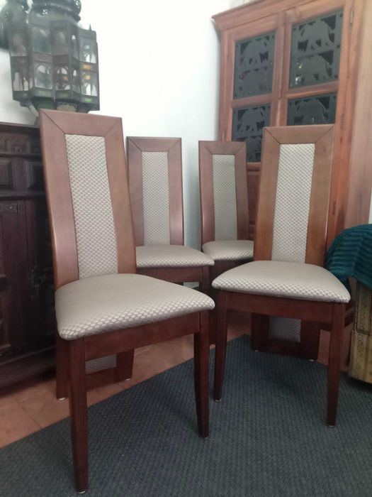 Cadeiras de sala de jantar em madeira com estofamento cinza.