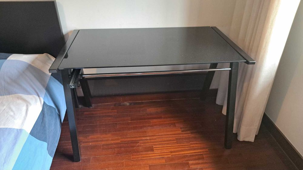 Secretária com tampo em vidro lacado preto e gaveta para teclado.