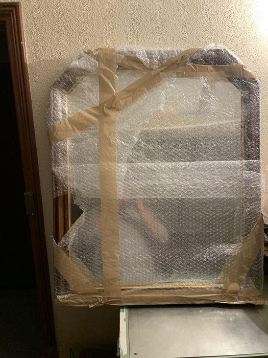 Espelho em moldura de madeira.