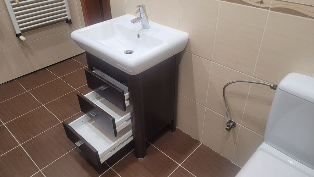 Cersanit, słupek, szafka z umywalką oraz bateria łazienkowa.