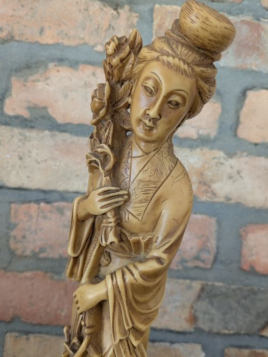 Decoração artesanal origem Ásia mulher com arranjo de flores