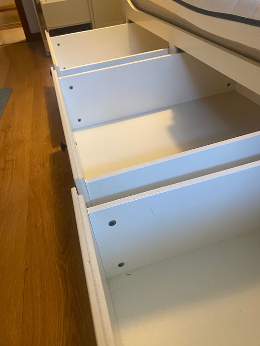 Um sofá, uma cama individual, uma cama de casal e arrumação