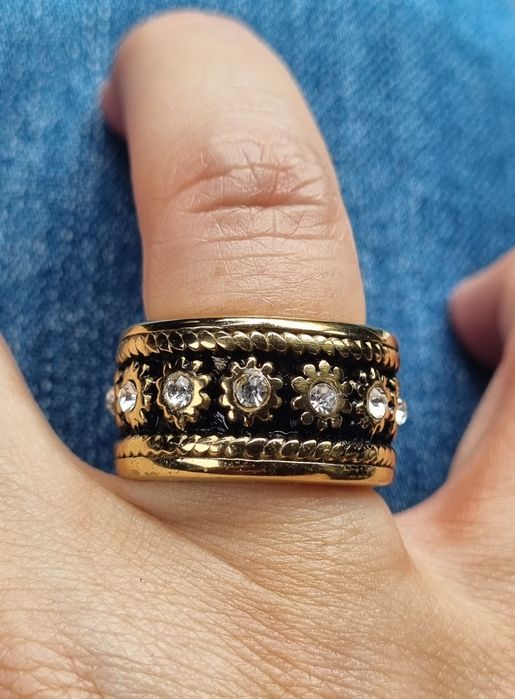 Anel dourado, em aço, com pontos de luz em fundo preto a toda a volta. T19