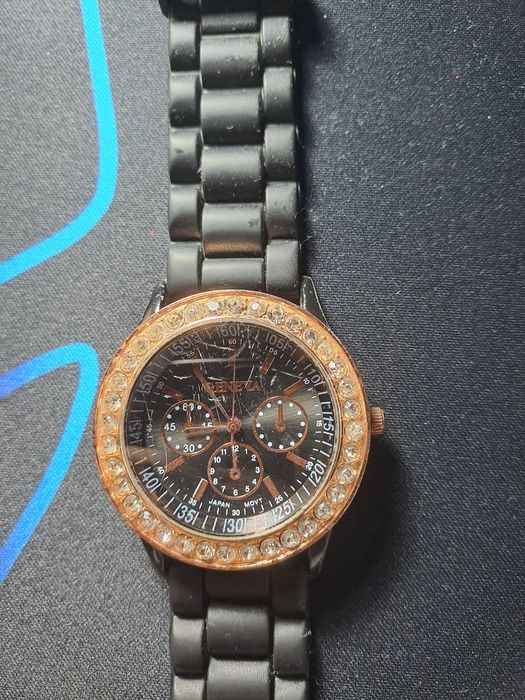 Relógio preto e dourado com pedrinhas