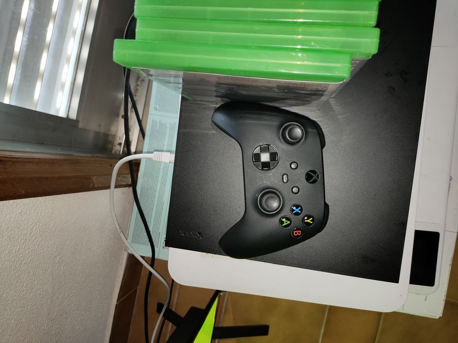 Xbox One X com jogos e headphone