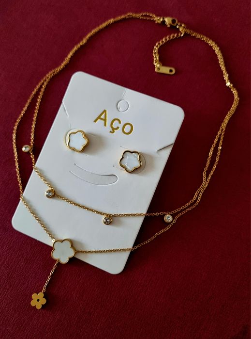Conjunto dourado (colar duplo e brincos), em aço, com flores brancas em madrepérola.