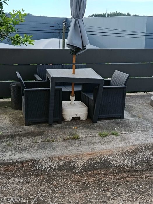 Mesa de jardim com duas cadeiras individuais e uma de dois lugares, guarda sol com a base incluído.