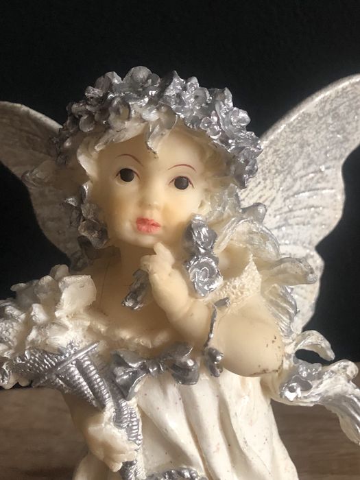 Figurka z żywicy Aniołek z różą i koszem kwiatów w ręku.