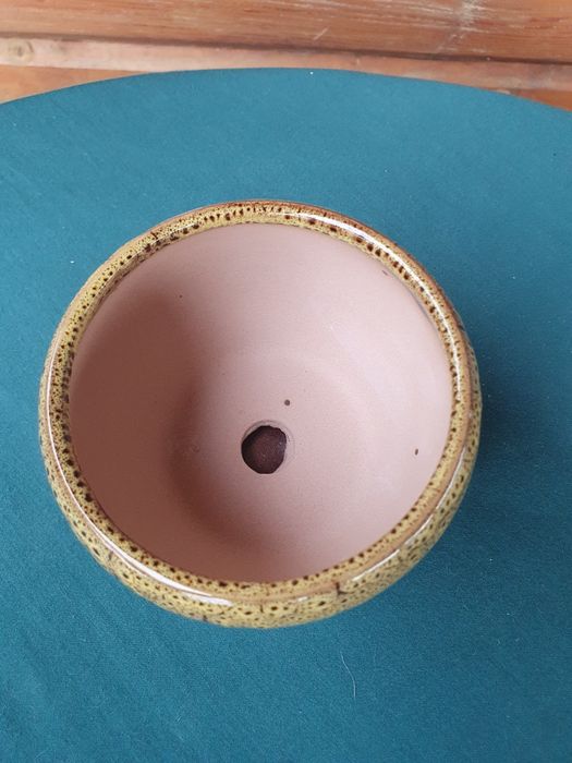 Żółta doniczka ceramiczna z przytwierdzoną podstawką