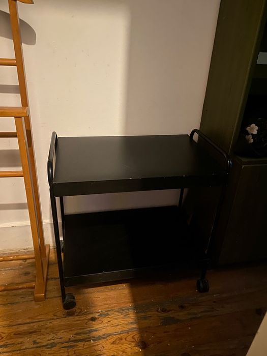 Um cabideiro de chão e mesa de apoio