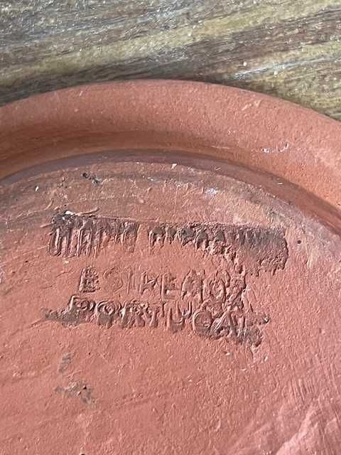 Garrafa pequena de barro com prato e copo