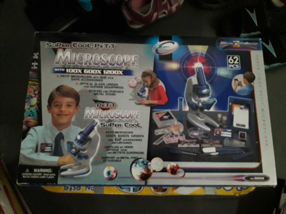 Microscópio e acessórios em caixa