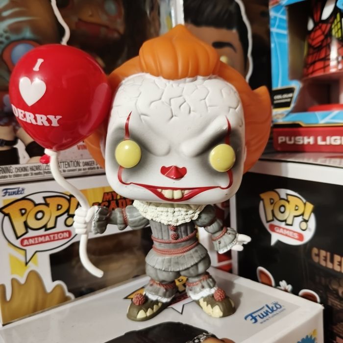 Figurka funko pop Pennywise'a z filmu IT, trzymającą czerwony balon