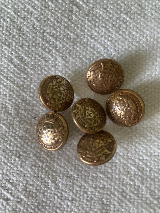 Guziki z metalu w kolorze starego złota.