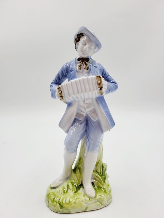 Ceramiczna pastelowa figurka muzykanta grajka z harmonią