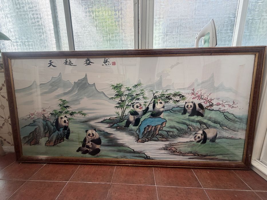 Esta é uma bela pintura em bordado de seda representando um panda.