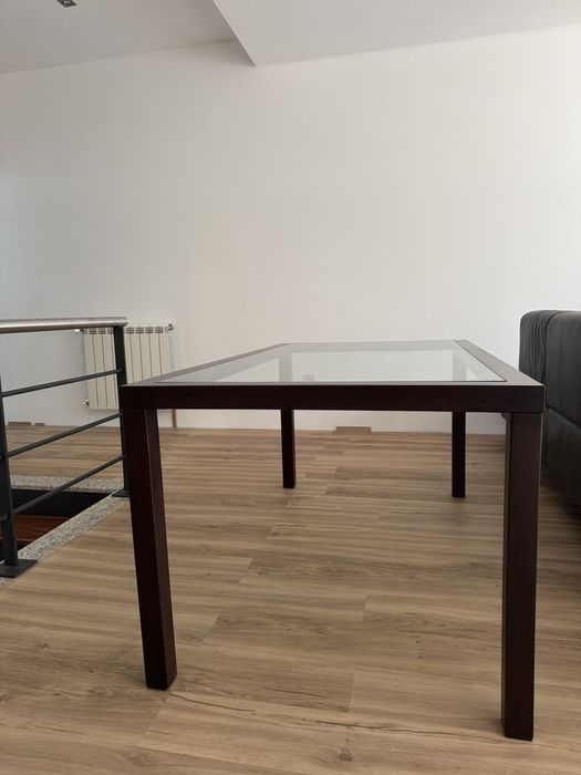 Mesa de jantar moderna em madeira escura com tampo em vidro