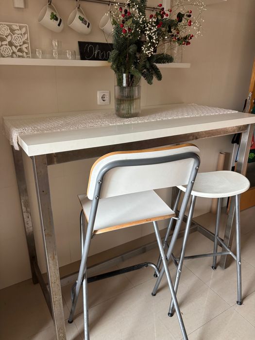 Mesa alta com duas cadeiras e um banco