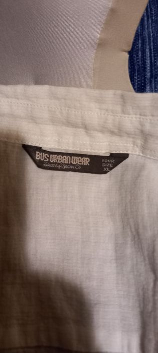 Camisa branca cintada da marca Bus.
É feita de um tecido enrugado que