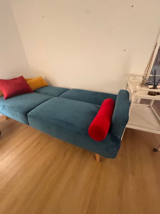 Sofá-cama verde com pufe