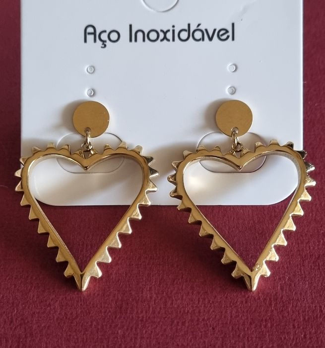 Brincos dourados, em aço, formato coração. 4cm de altura. De pico.