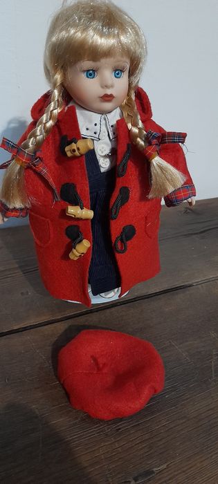 Boneca loiça e pano, com suporte em metal