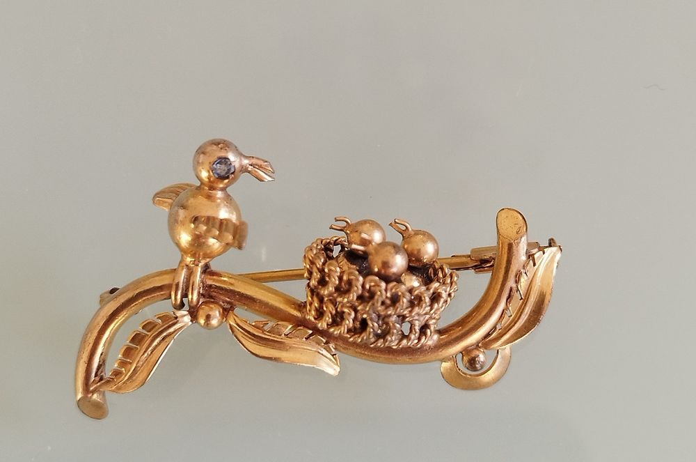 Lindo broche antigo em latão. Pássaros num ninho.