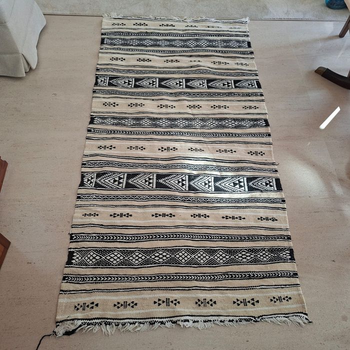 Tapete artesanal preto e branco usado.