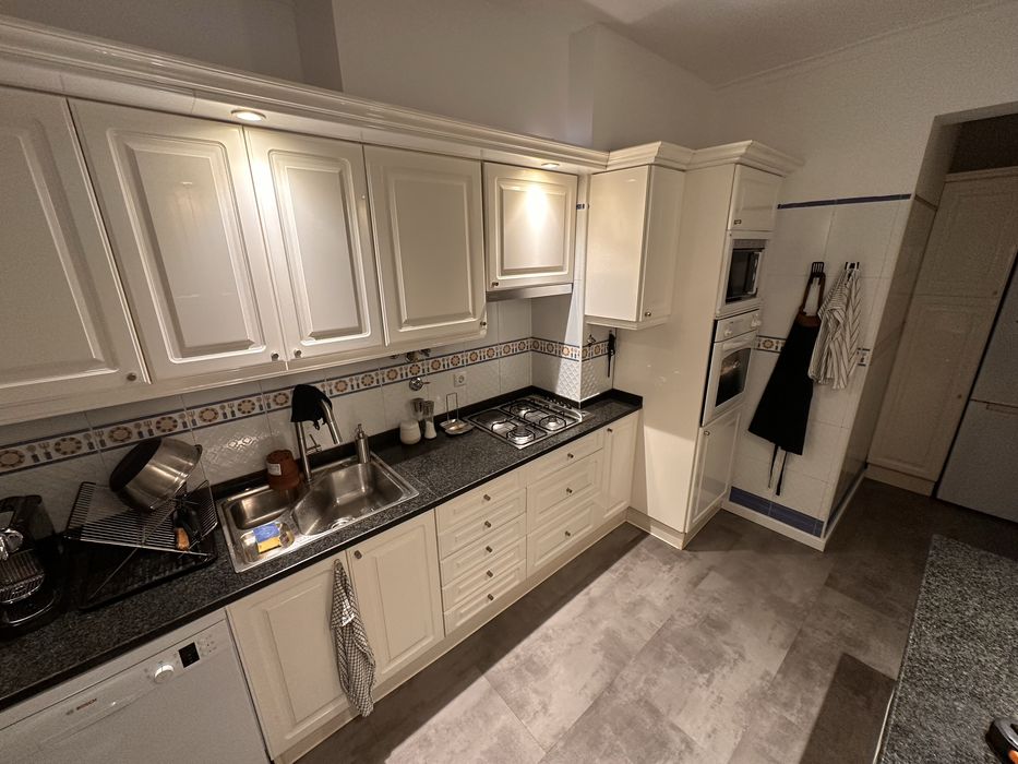 Cozinha em madeira lacada com bancada em granito e península