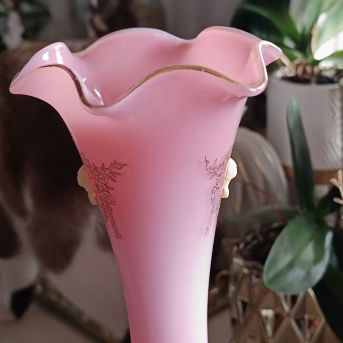 Uma imponente jarra rosa opalescente, com sua abertura rendada