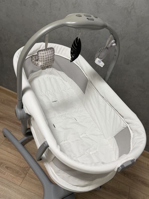 Кроватка-стульчик Chicco Baby Hug Air 4-в-1 в белом цвете с сетчатыми боковинами для вентиляции.