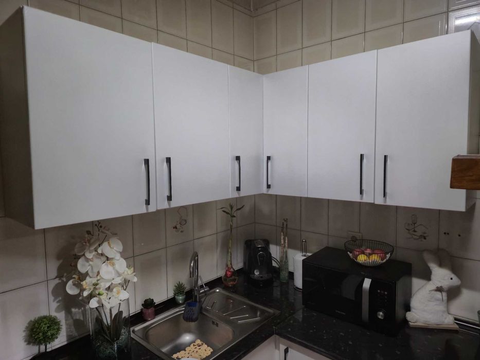 Balcão de cozinha juntamente com armários e um sofá com mesa