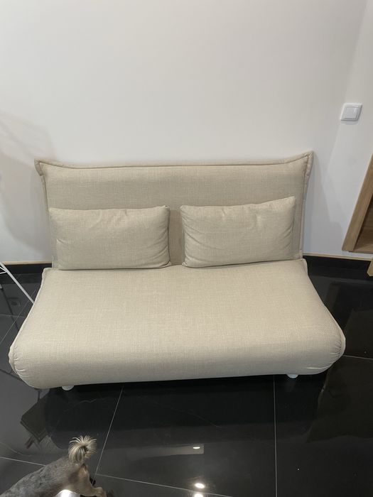 Sofá cama com duas almofadas.