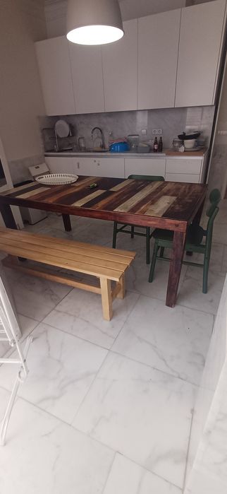 Mesa de jantar/cozinha área antiga com duas cadeiras verdes e banco corrido