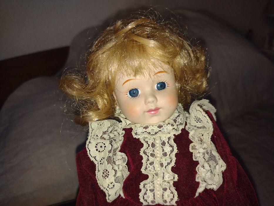 Porcelain doll with burgundy velvet dress