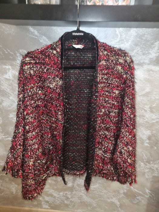 Śliczny kardigan z rękawami typu nietoperz zakończonymi frędzlami.