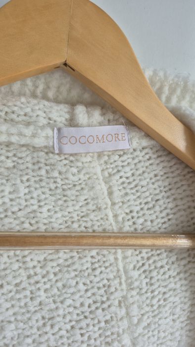 Damski kardigan z kapturem w kolorach kremowym, niebieskim i beżowym.