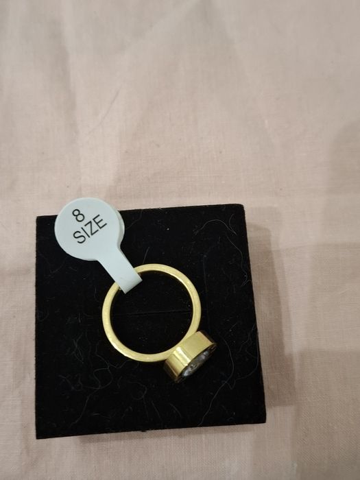Anel dourado com brilhante e números romanos em Aço Novo